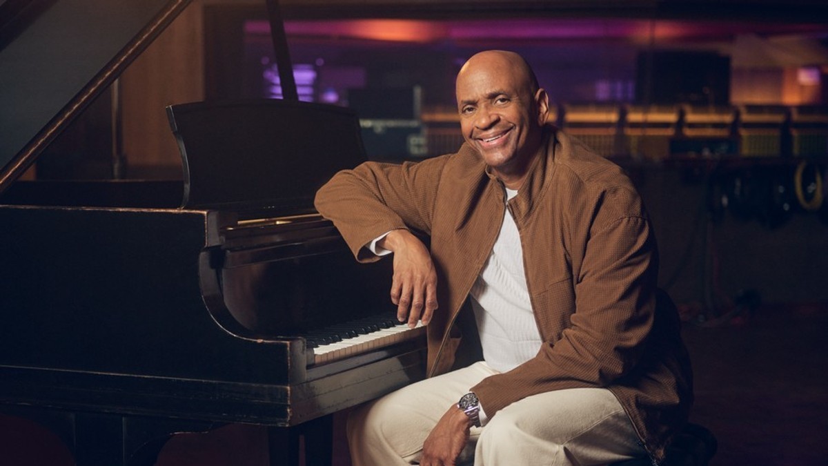 Sergio George sitting at a piano in Apple’s Creator Studio press photograph.