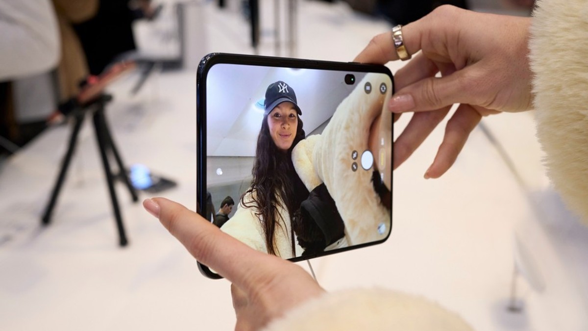 A customer’s hands holding an unfolded iPhone Duo at Apple’s October 23 launch.