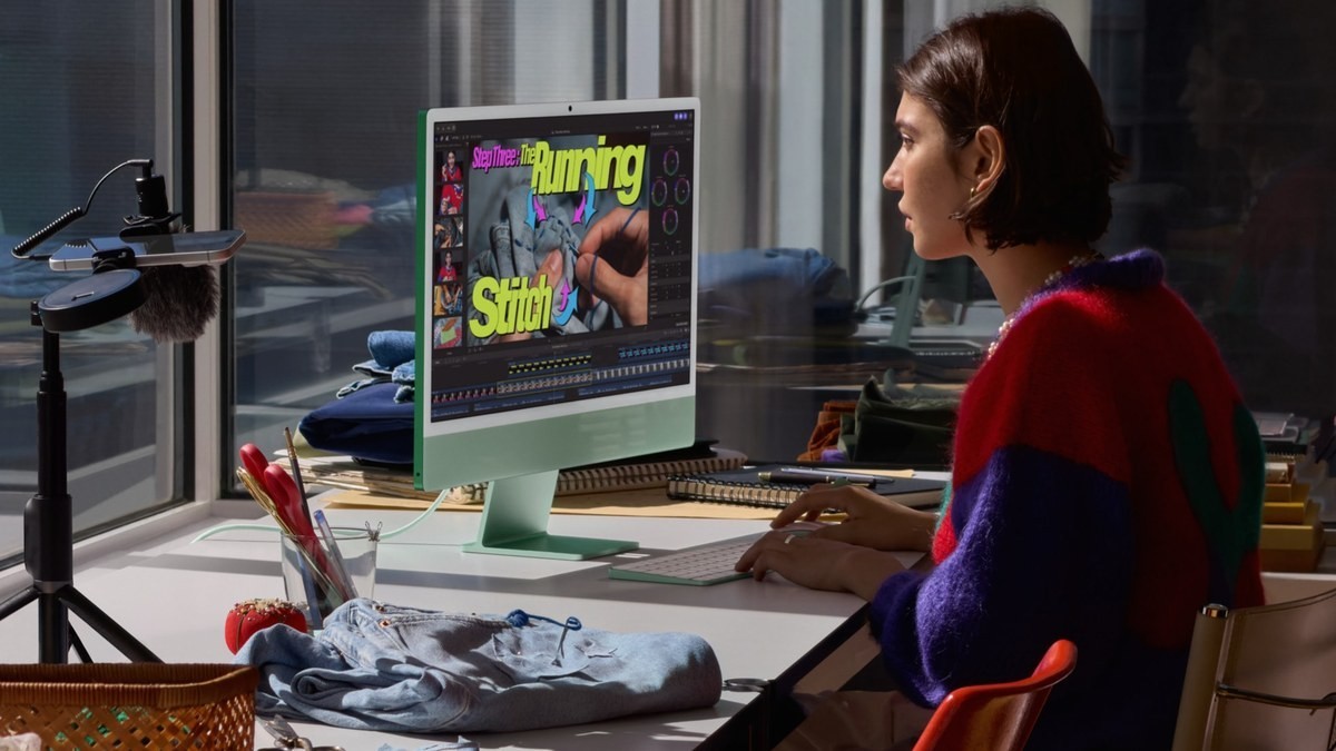 A creator edits a sewing video on a green iMac with M6 at a worktable