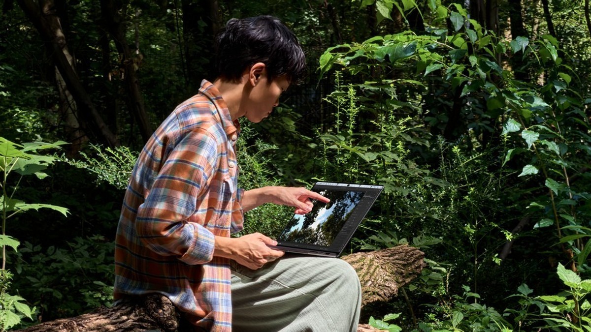 A person uses the new MacBook Pro with PROLED XDR Display outdoors in bright daylight.