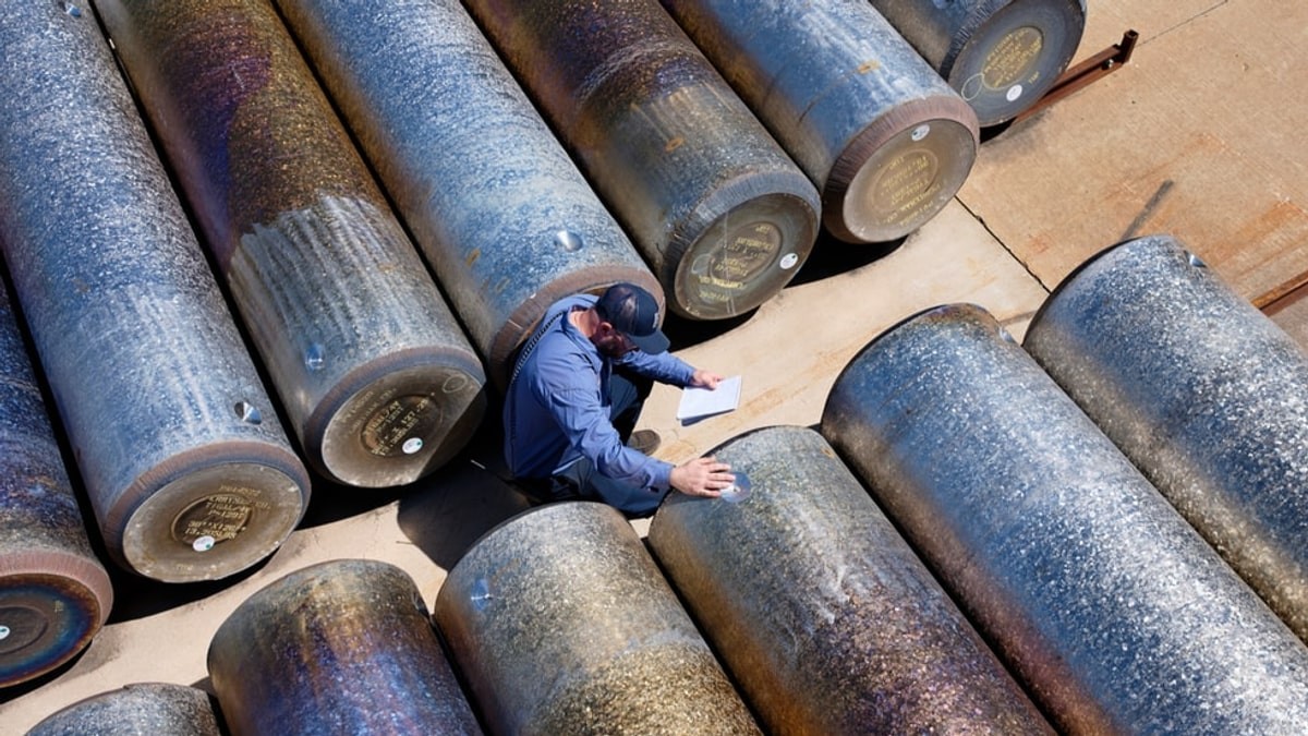 A Perryman employee checks titanium stock at a manufacturing facility, in Apple’s official American Manufacturing Program photograph.